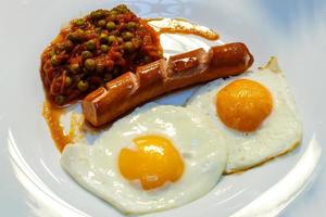 Fried eggs and fried sausage for breakfast. photo