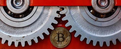 engranajes y cogs de cerca y moneda bitcoin foto