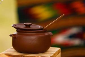 Dirty ceramic pot on old wooden kitchen board photo