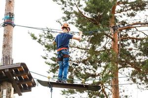 joven europeo camina por una línea apretada en un parque de la ciudad. el chico se balancea en el slackline. foto