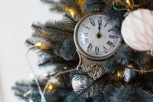 Merry christmas and happy new year clock cut out of paper surrounded by fir tree branches photo