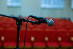 Microphone over the abstract blurred of conference hall or seminar room background photo