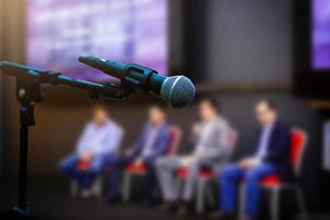 Microphone in front businesspeople blurred in conference meeting room photo