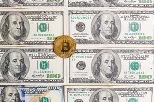 Golden bitcoin coin on us dollars close up photo