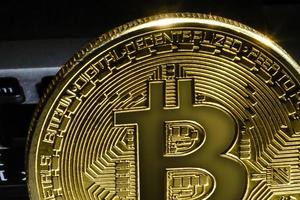 bitcoin dorado con tarjeta de crédito sobre fondo de billetes en dólares, nueva moneda, aceptando bitcoin para pago, concepto financiero, espacio de copia foto