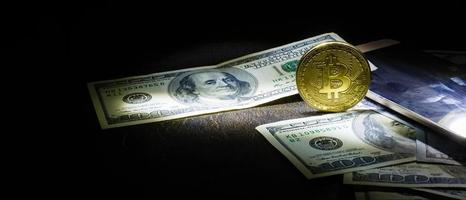 bitcoin dollars on a black background Golden bitcoins with the spotlight photo