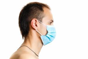 Young male doctor in medical mask isolated on white photo