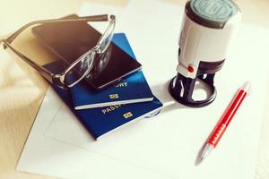 Passport on declaration card with glasses and pen photo