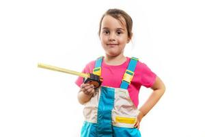 Little girl using a measuring tape over white background photo