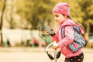 adolescente feliz sostenga los auriculares y una pequeña sonrisa foto