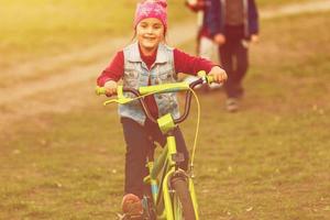 Little girl riding bike at sunset photo