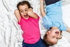 Happy little girls lying on back top view photo