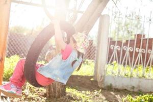 Happy Llittle girl playing swing at park photo