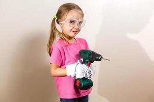 Little smiling girl holding a drill photo