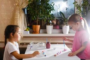 Two cute little sisters drawing with colorful at a daycare creative kids painting together photo