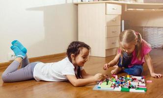 dos niños pequeños están jugando con bloques niñas felices en casa graciosas hermanas encantadoras foto