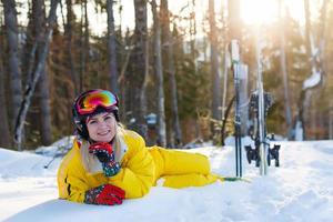 Ski, snow and sun - resting female skier in winter resort photo