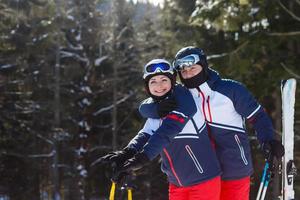 Portrait of smiling couple on skis in the mountains photo