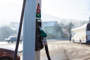 dispensador de combustible con boquilla de gas en gasolinera en temporada de invierno foto
