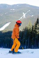 Side view of skier looking at snow covered mountains photo