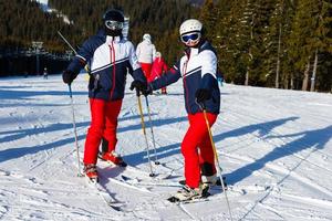 Portrait of smiling couple on skis in the mountains photo