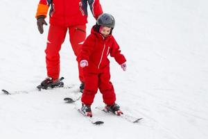 Cute little girl learning to ride on the skis child making its first steps outdoor fun for family photo