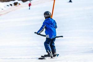 children on a ski lift, ski-lift and snow-capped mountains. photo