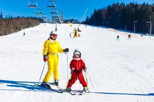 mother and daughter in bright winter ski suits photo