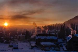 casa de nieve en el país de los sueños de invierno al amanecer en el bosque, clima antiguo y mucha nieve en el techo foto