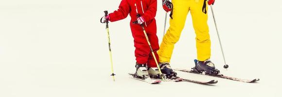 Little girl and a woman skiers on the top of a snowy mountain slope going to ski photo