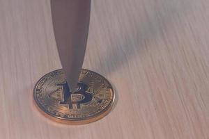 Blade of a knife on a gold coin bitcoin photo