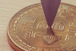 Blade of a knife on a gold coin bitcoin photo