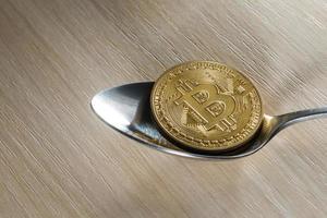 Golden bitcoin on spoon photo