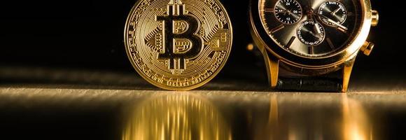 Bitcoin time concept on creative background.. Golden Bitcoin over the watch . Time cryptocurrency concept . photo