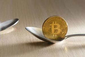 Golden bitcoin on spoon