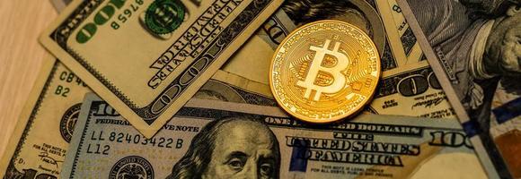 versión física de bitcoin nuevo dinero virtual y billetes de un dólar. cambiar bitcoin por un dolar. imagen conceptual para la criptomoneda mundial y el sistema de pago digital. foto