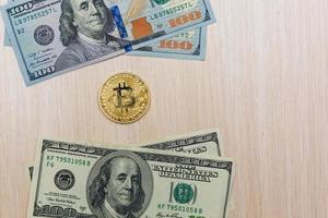 Golden bitcoin coin on us dollars close up photo
