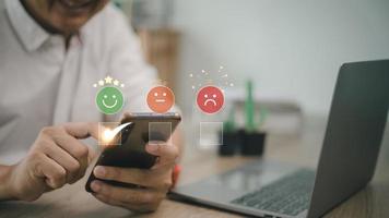 man use smartphone choosing green happy smile face icon. feedback rating and positive customer review experience, satisfaction survey. mental health assessment. world mental health day concept photo