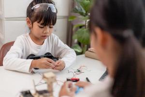 Asia students learn at home in coding robot cars and electronic board cables in STEM, STEAM, mathematics engineering science technology computer code in robotics for kids concept. photo