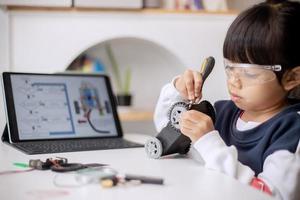 Asia students learn at home in coding robot cars and electronic board cables in STEM, STEAM, mathematics engineering science technology computer code in robotics for kids concept photo