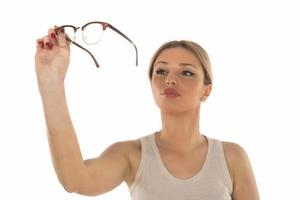 a young woman chooses a frame for her new glasses on white background photo