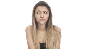 funny female model over white background crosses eyes and makes fish lips funny grimace photo