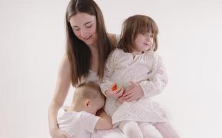 Family in the studio having fun isolated on white background. Dad, mom and two children hug and smile photo