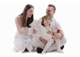 Family in the studio having fun isolated on white background. Dad, mom and two children hug and smile photo