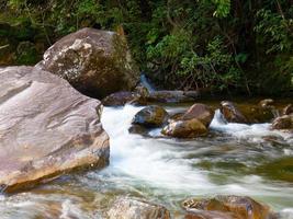 hermosa cascada con aguas cristalinas borrosas fotografiadas en larga exposición foto