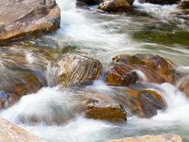 hermosa cascada con aguas cristalinas borrosas fotografiadas en larga exposición foto
