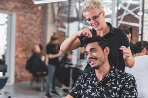 Professional hairdresser is cutting men's hair in beauty salon. photo