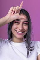 niña morena sonriente coqueteando y tocando su cabello largo y hermoso foto