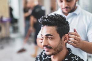 peluquero profesional está cortando el pelo de los hombres en el salón de belleza. foto