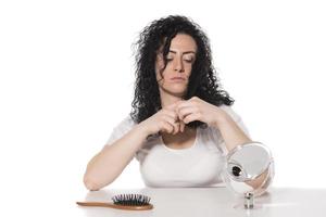 hair problems. young woman checking her damaged, and split hairs photo